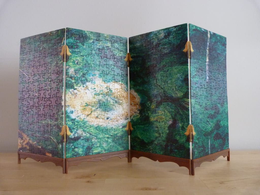 A folding four-panel screen featuring a marbled, green malachite pattern.