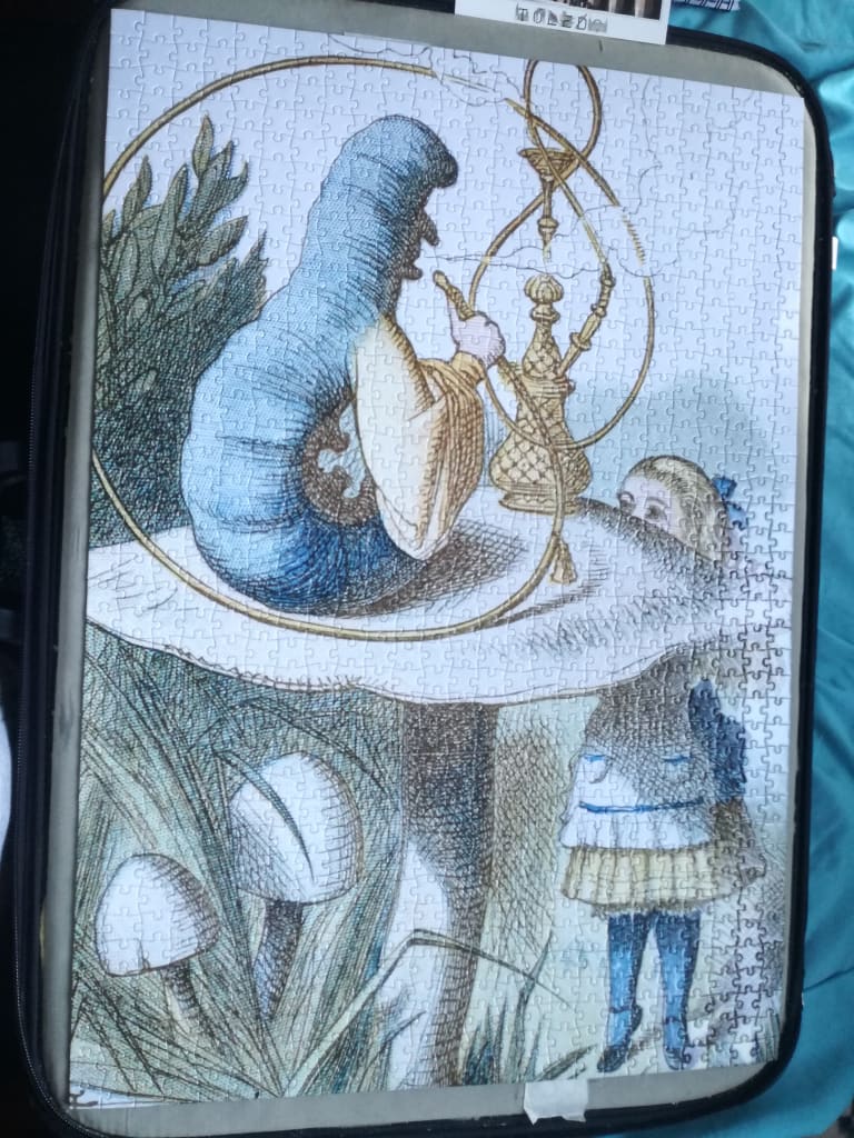 A classic illustration of the Caterpillar smoking a hookah on a mushroom, with Alice standing beside it.