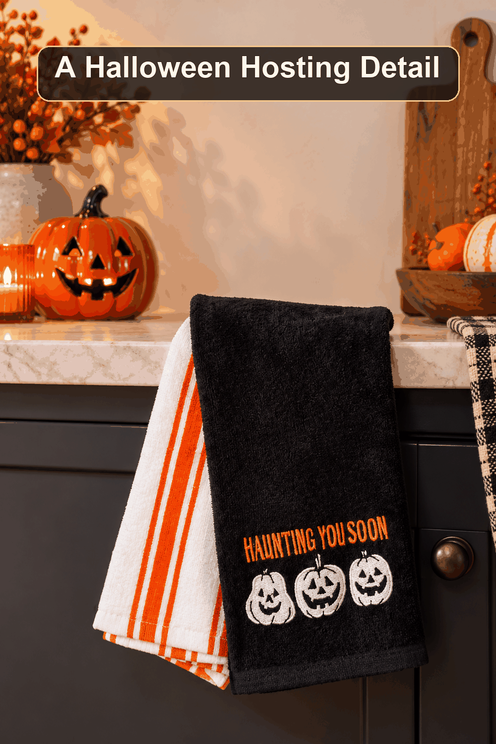 Styled Halloween home scene featuring the 2-Pack Happy Haunting Pumpkin Hand Towels, with the words A Halloween Hosting Detail in a dark banner above.