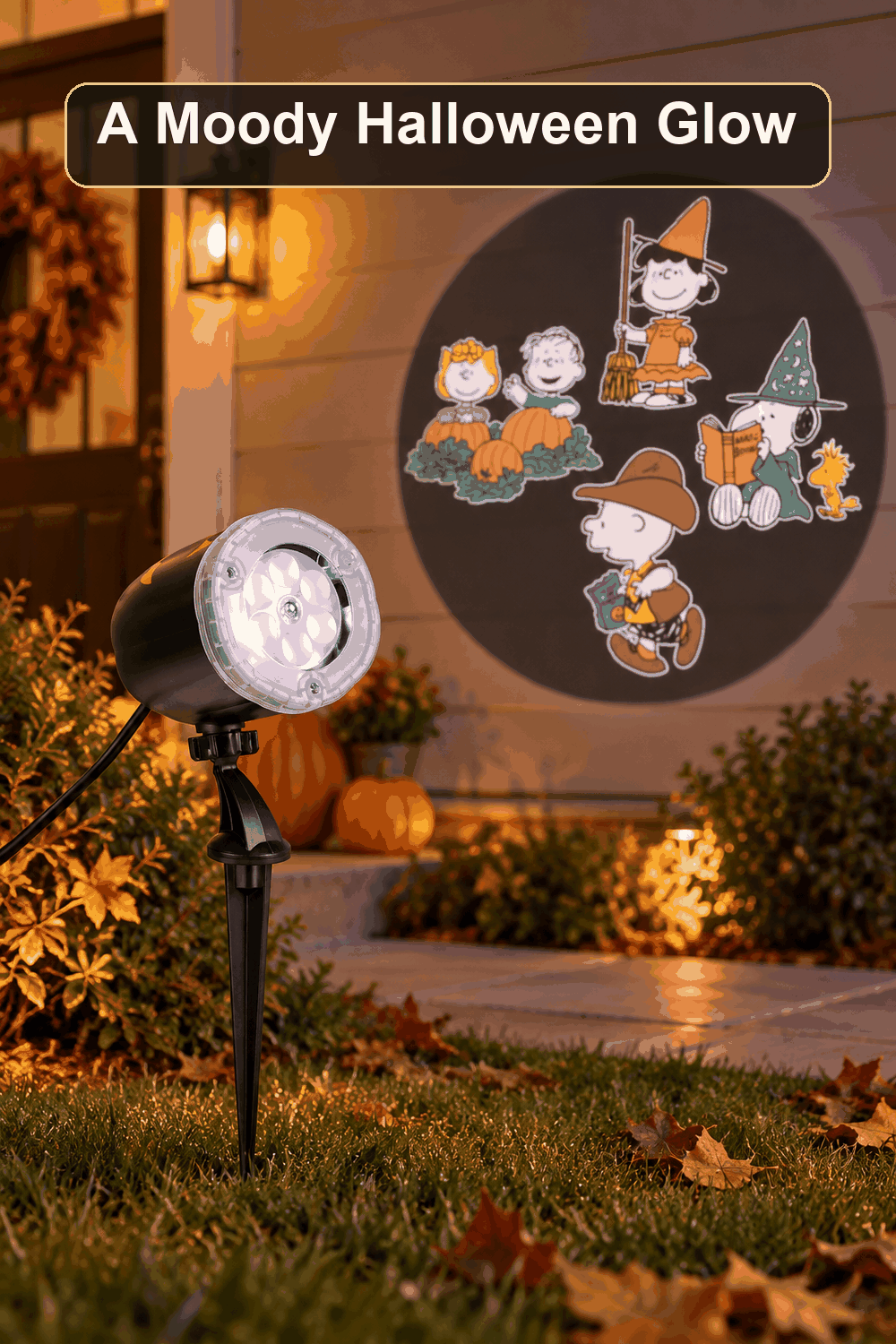 Styled Halloween home scene featuring the Peanuts Projection Lights, with the words A Moody Halloween Glow in a dark banner above.