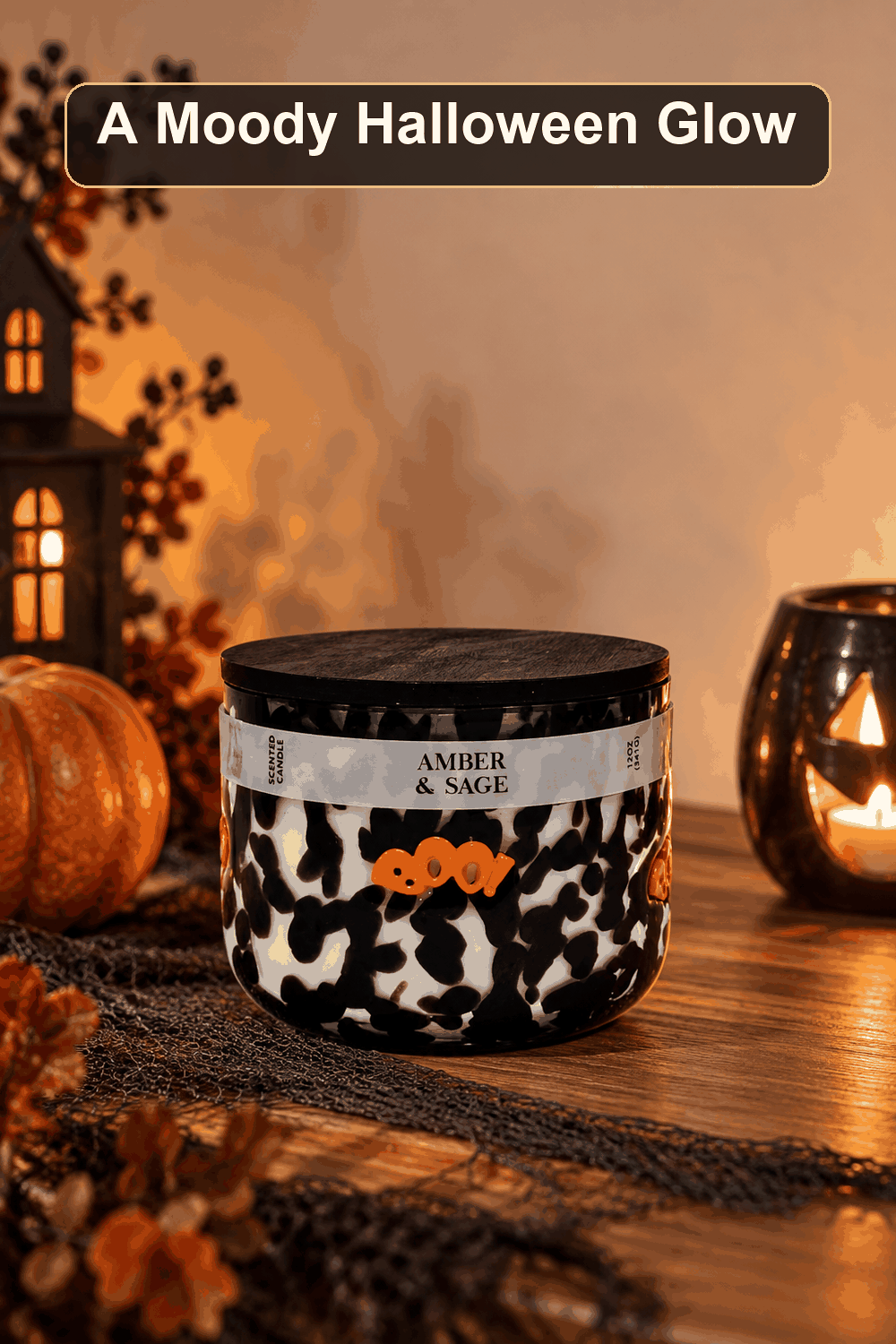 Styled Halloween home scene featuring the Amber & Sage Scented Icon Jar Candle, 12oz, with the words A Moody Halloween Glow in a dark banner above.
