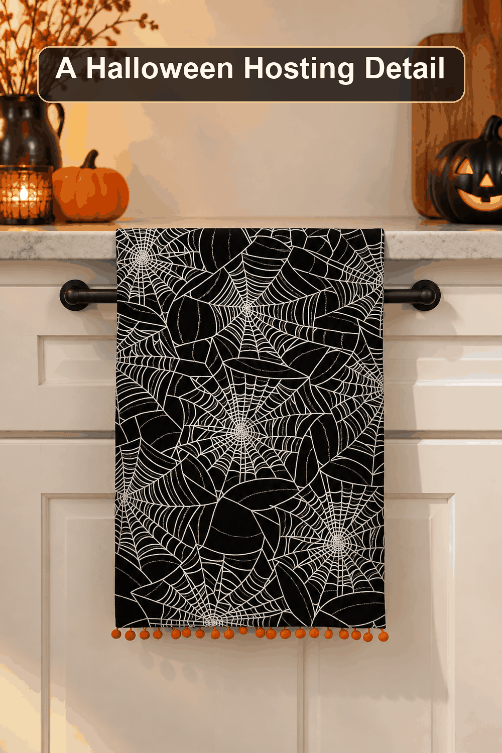 Styled Halloween home scene featuring the Halloween Web Embroidered Kitchen Towel, 16x26, with the words A Halloween Hosting Detail in a dark banner above.