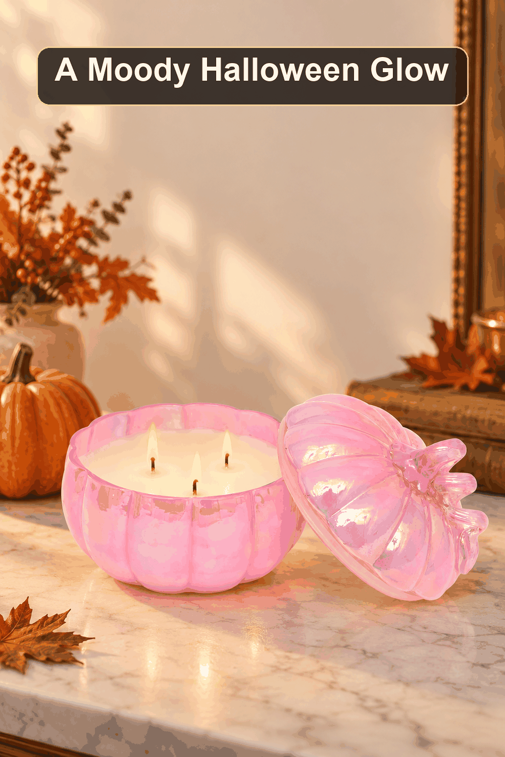 Styled Halloween home scene featuring the Pink Glass Pumpkin Candle, 21oz, with the words A Moody Halloween Glow in a dark banner above.