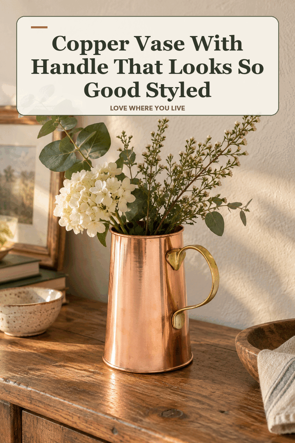 A realistic lived-in home scene featuring the exact Biltmore Copper Vase with Handle, beneath the words Copper Vase With Handle That Looks So Good Styled.