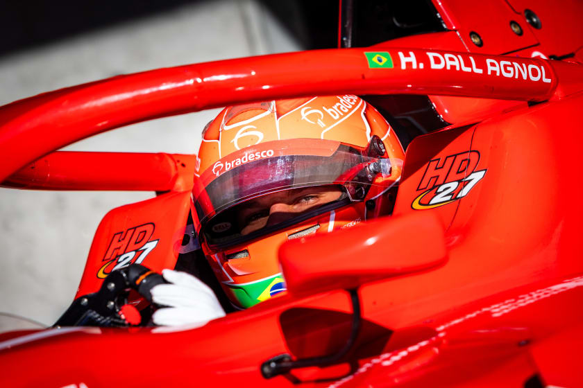 Helmeted in the cockpit, his name printed along the side of the car
