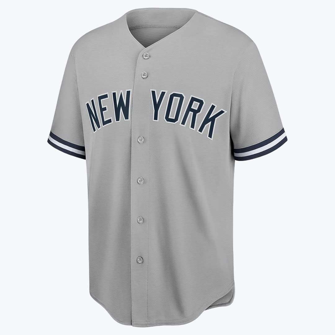 New York Yankees Grey Road Baseball Jersey A grey New York Yankees road baseball jersey with NEW YORK in navy blue and white lettering across the chest, featuring a button-down front and striped sleeve cuffs.