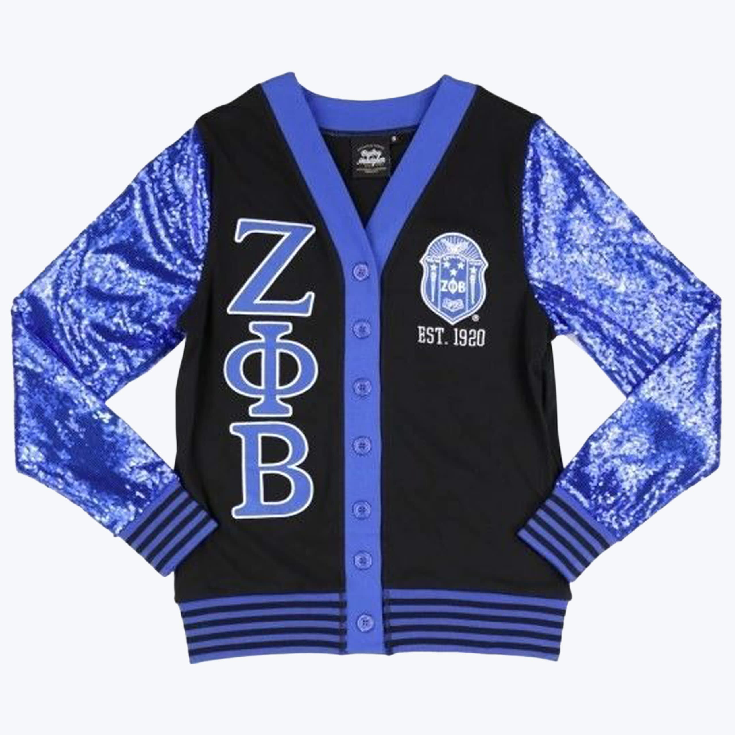 Zeta Phi Beta Sequined Sleeve Cardigan A black cardigan with royal blue sequined sleeves, featuring the Greek letters Zeta Phi Beta on the left and the sorority crest with EST. 1920 on the right.
