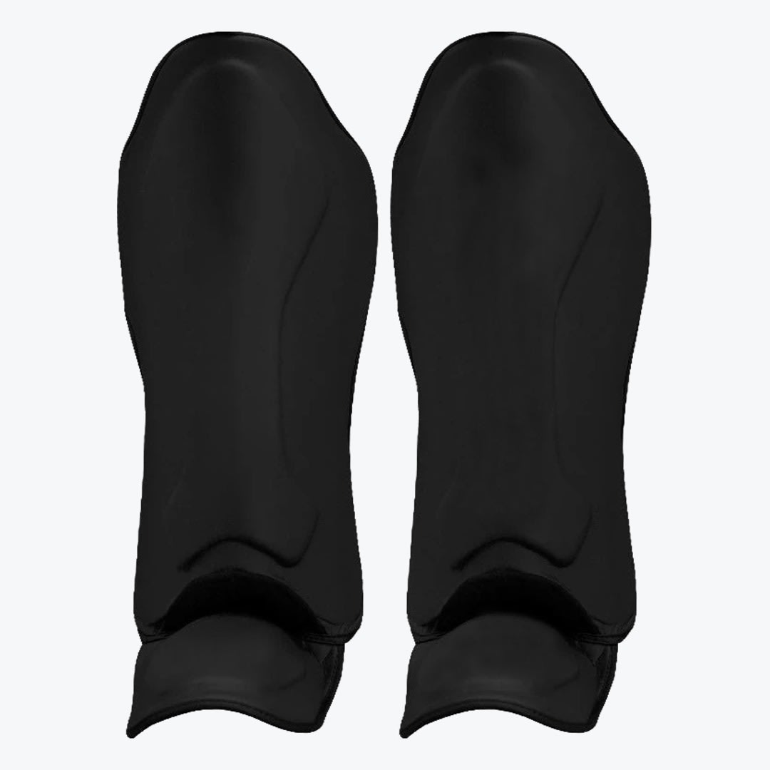 Black Shin Guards with Ankle Protection A pair of solid black athletic shin guards with built-in ankle sleeves on a white background.