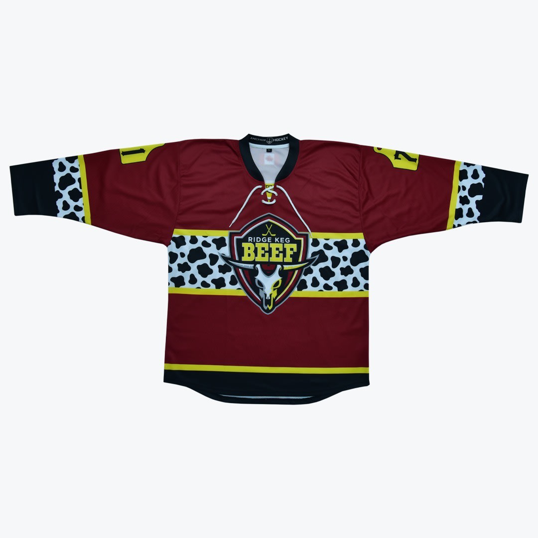 Ridge Keg Beef Hockey Jersey A maroon hockey jersey with a cow print pattern and a Ridge Keg Beef logo featuring a bull skull.