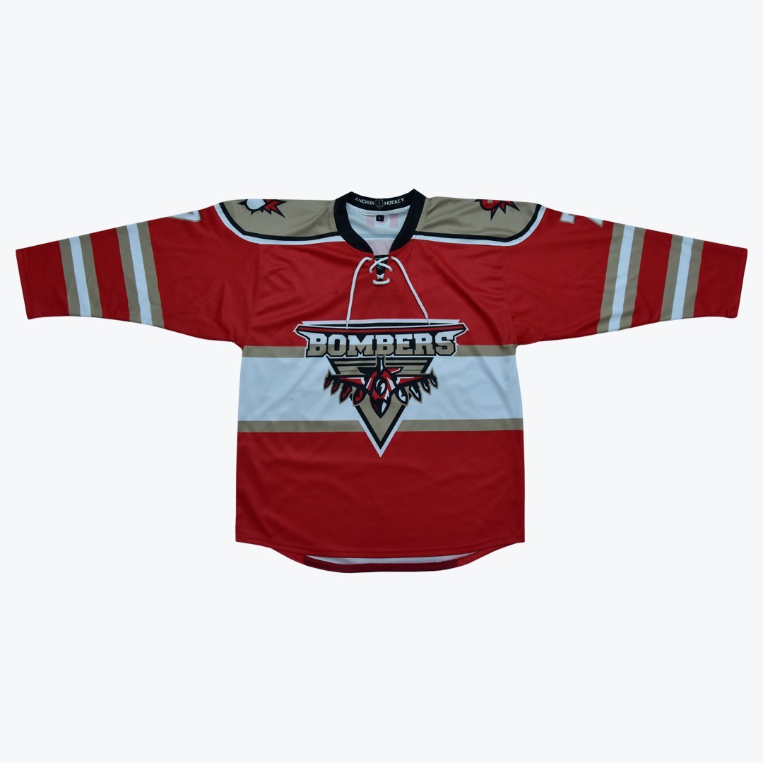 Red and Gold Bombers Hockey Jersey A flat-lay image of a red hockey jersey with BOMBERS printed on the front over a white and gold stripe, featuring a lace-up collar.