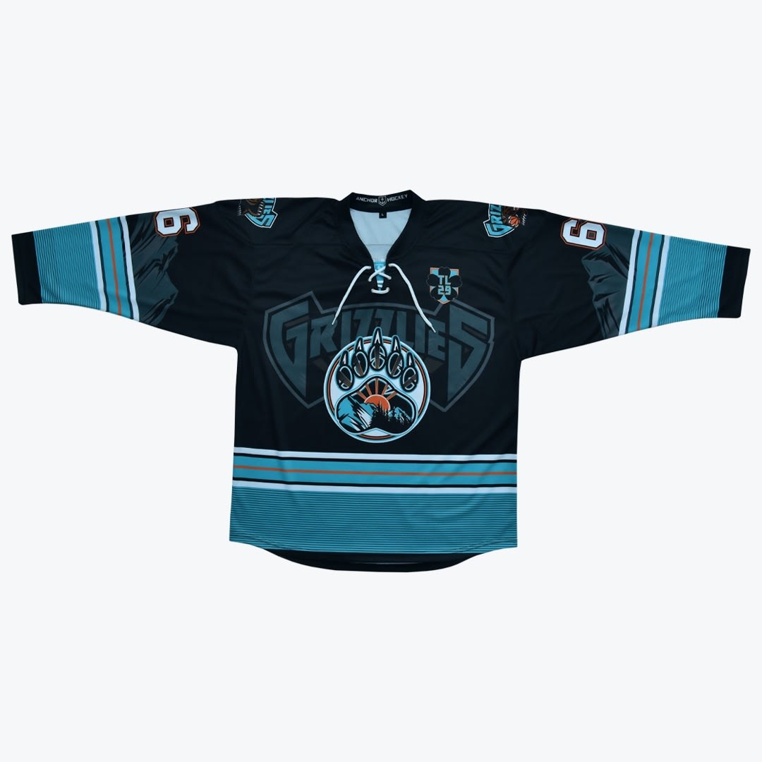 Grizzlies Custom Hockey Jersey A black, teal, and orange hockey jersey with a Grizzlies logo and a bear paw mountain graphic on the front.