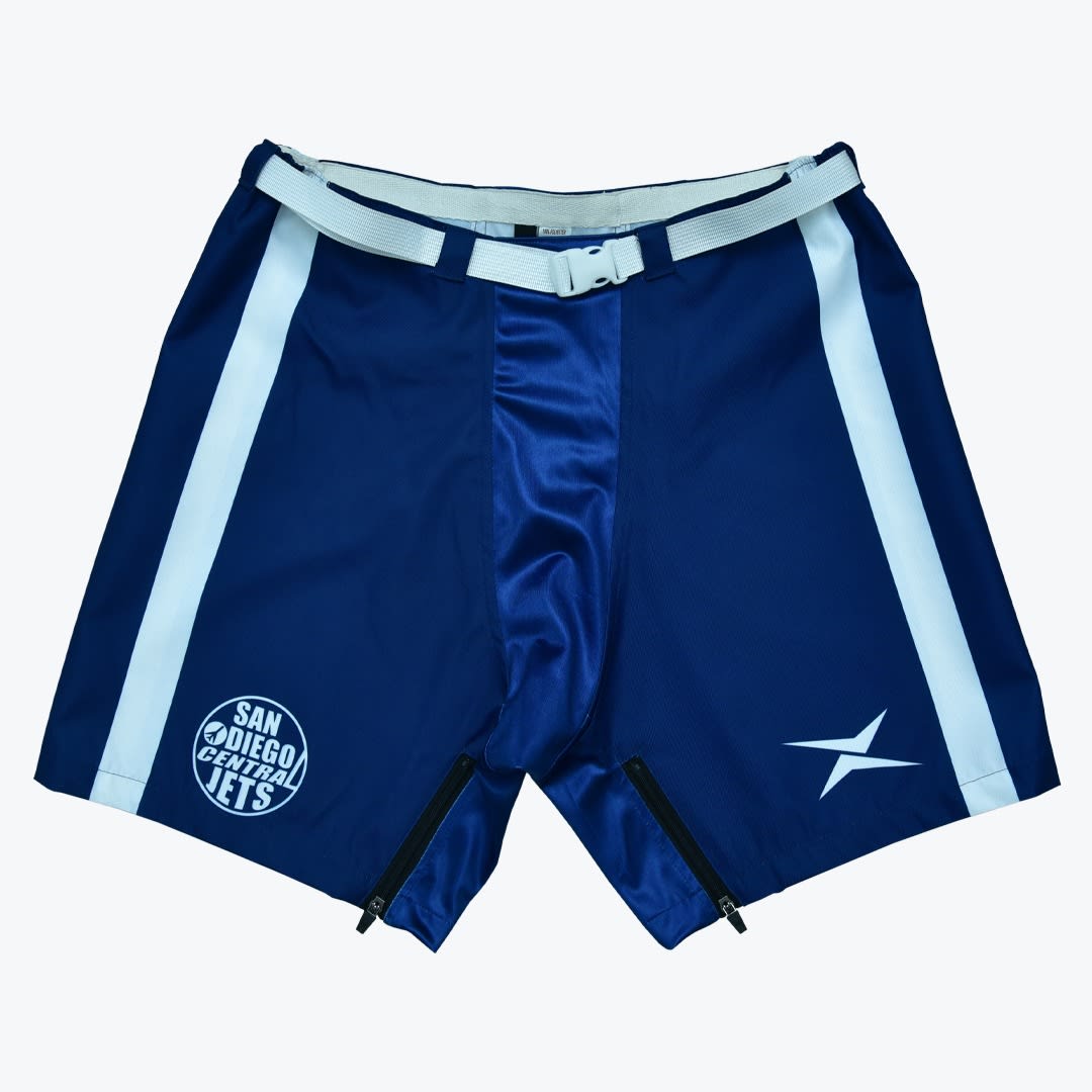 San Diego Central Jets Blue Athletic Shorts Royal blue athletic shorts with a white belt, white side stripes, a San Diego Central Jets logo, and zippered inner thighs against a white background.