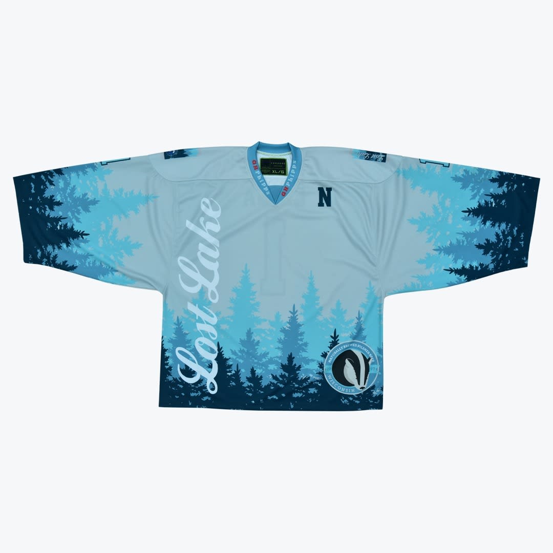 Custom Lost Lake Wisconsin Badger Hockey Jersey A light blue custom hockey jersey with a blue pine forest graphic, featuring Lost Lake script and a circular Wisconsin badger logo.
