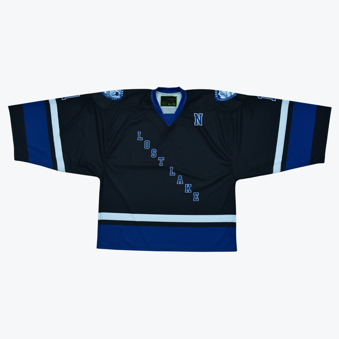 Lost Lake Hockey Jersey A black hockey jersey with LOST LAKE written diagonally in blue letters, featuring blue and white stripes on the sleeves and bottom hem.