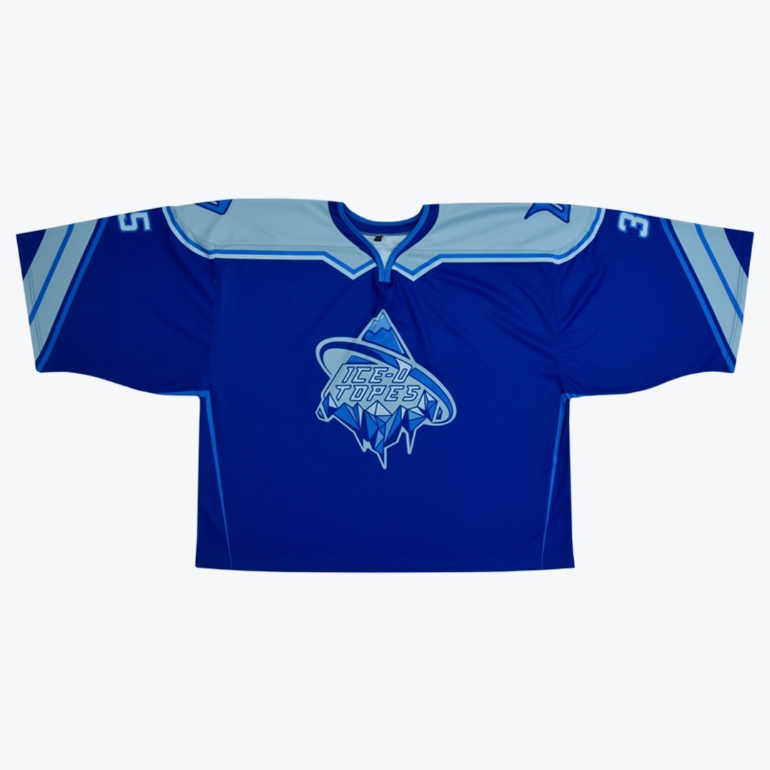 Ice-O-Topes Blue Hockey Jersey A blue hockey jersey with the Ice-O-Topes logo on the front, displayed flat against a white background.