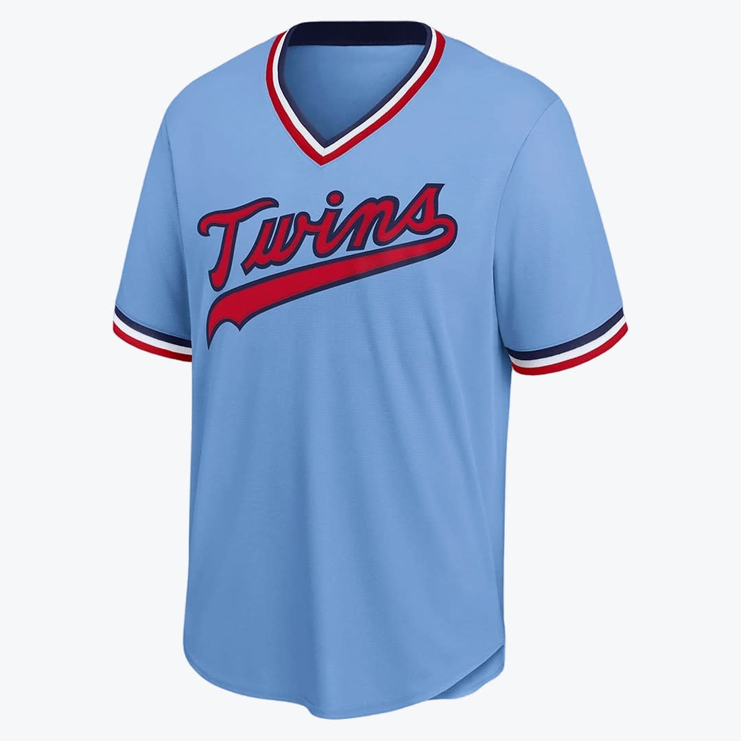 Minnesota Twins Powder Blue Jersey A light blue Minnesota Twins baseball jersey with red script lettering and striped trim on the collar and sleeves.