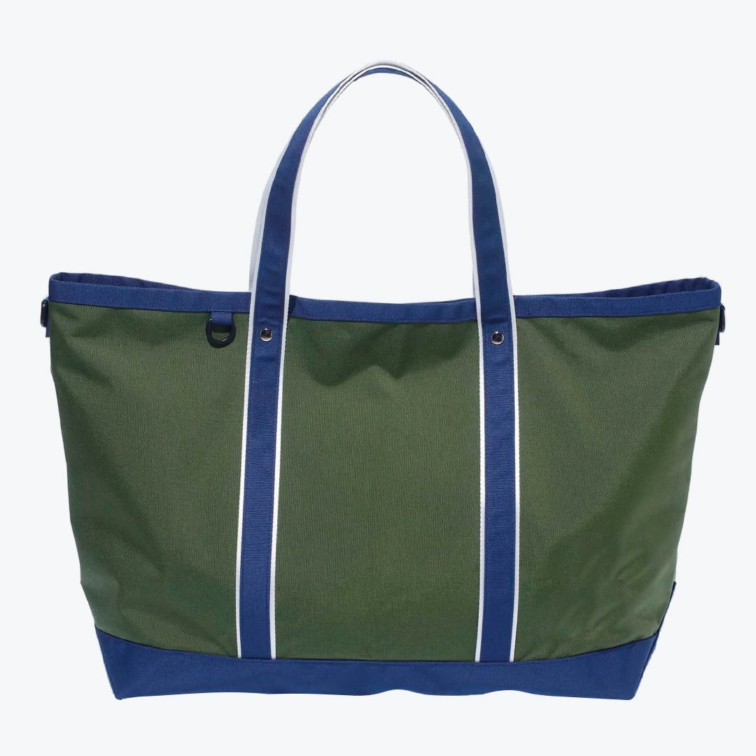 Green and Navy Canvas Tote Bag An olive green canvas tote bag with navy blue handles and base, featuring white stripes on the handles and a small D-ring on the front, isolated on a white background.