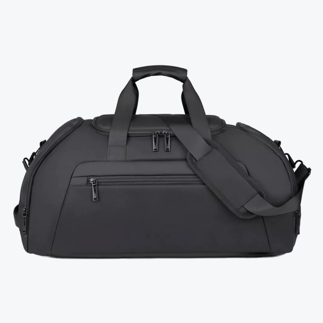 Black Travel Duffel Bag A front-facing studio shot of a matte black travel duffel bag with multiple zippered compartments, top handles, and an adjustable shoulder strap against a plain white background.