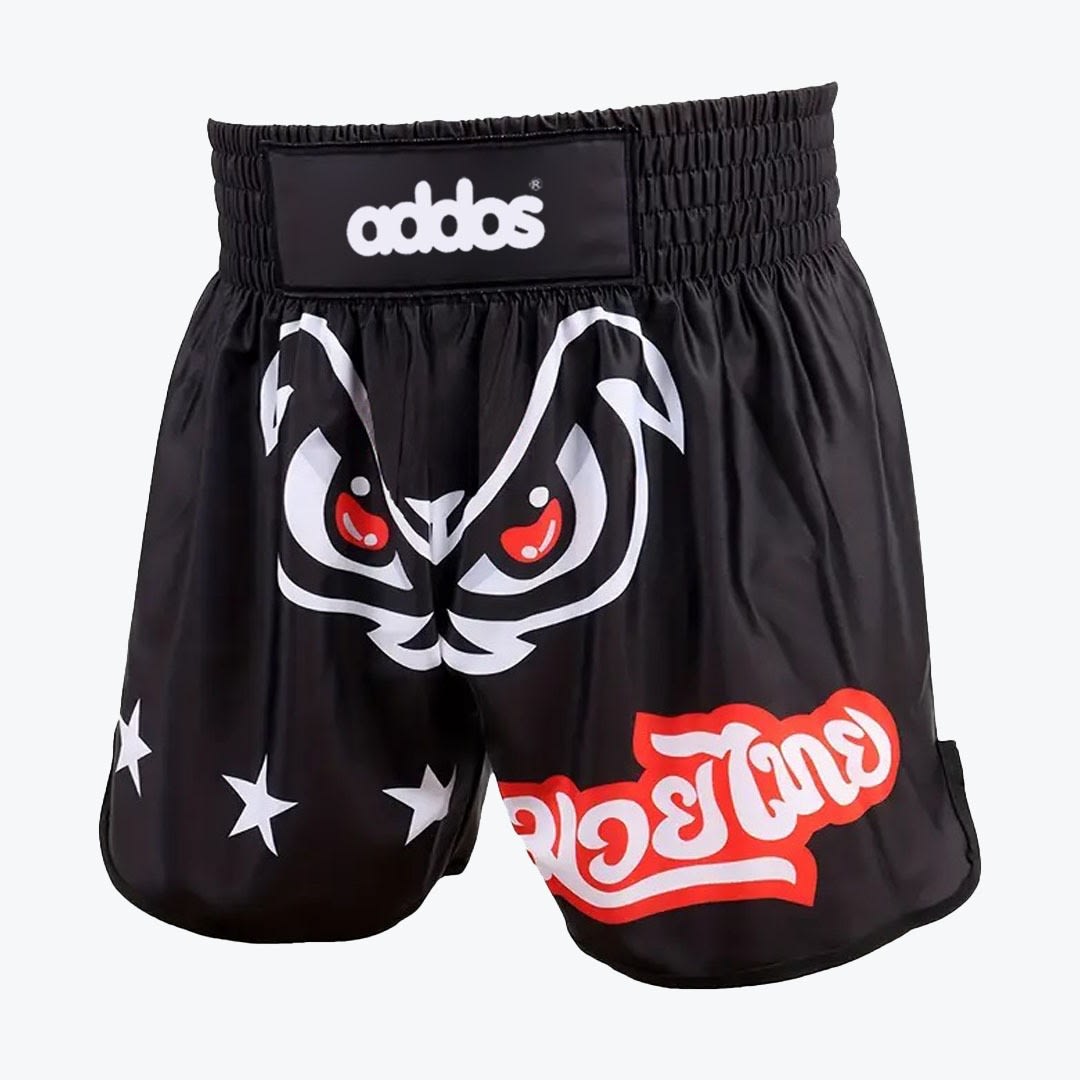 Black Muay Thai Shorts with Angry Eyes Graphic A pair of black Muay Thai shorts with an elastic waistband, featuring a white and red angry eyes graphic in the center, Thai script on one leg, and three white stars on the other.