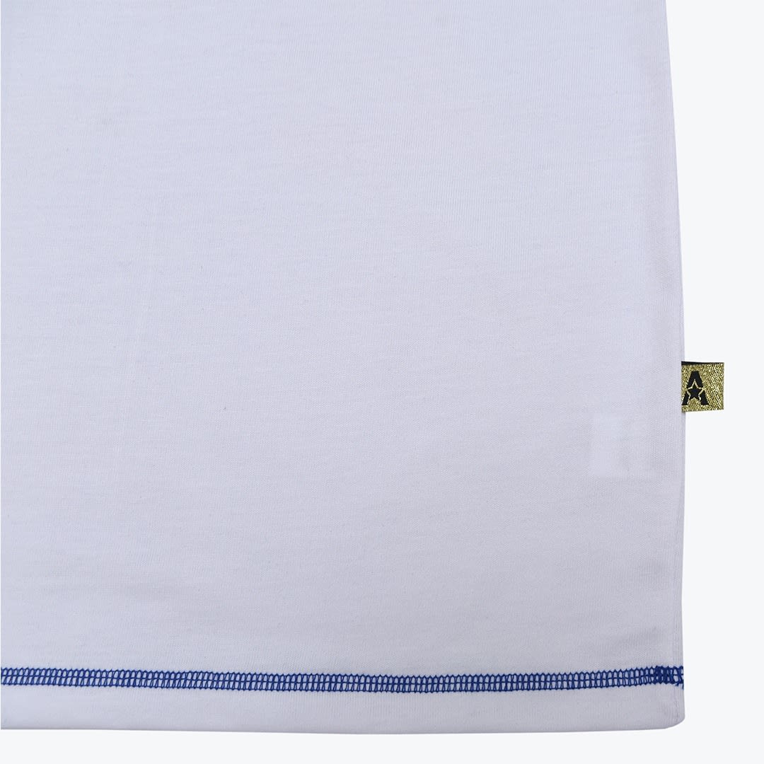 Close-up of a white shirt hem with blue stitching and a small gold tag with a star logo on the side.