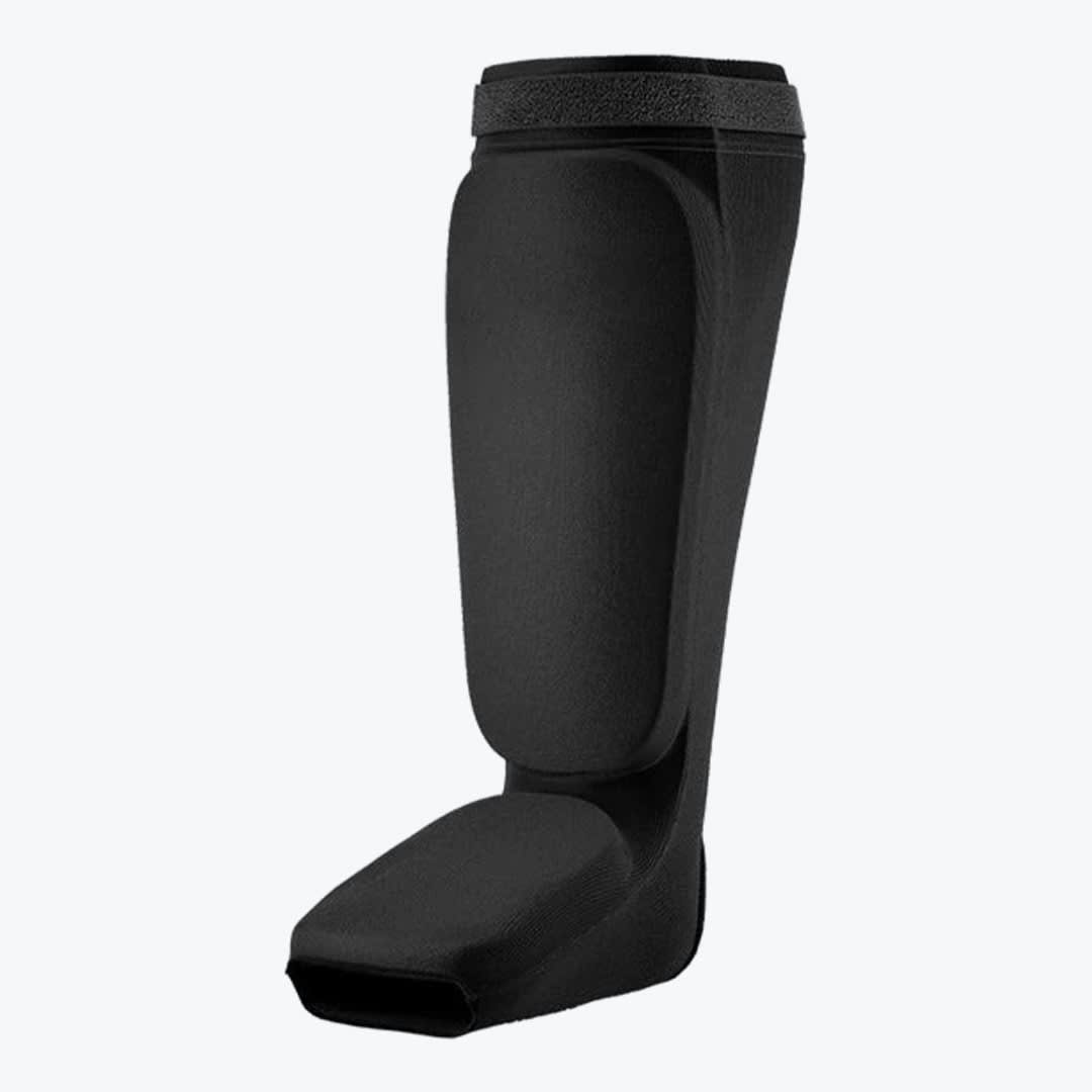A black slip-on shin and instep guard for martial arts training, shown against a plain white background.
