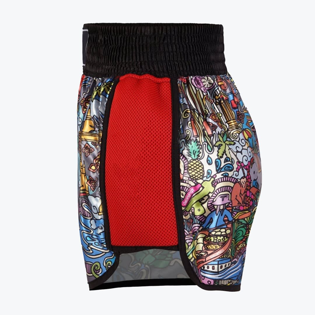 A side view of colorful Muay Thai shorts featuring a black waistband, a red mesh side panel, and a vibrant cartoon print of Thai cultural elements against a white background.