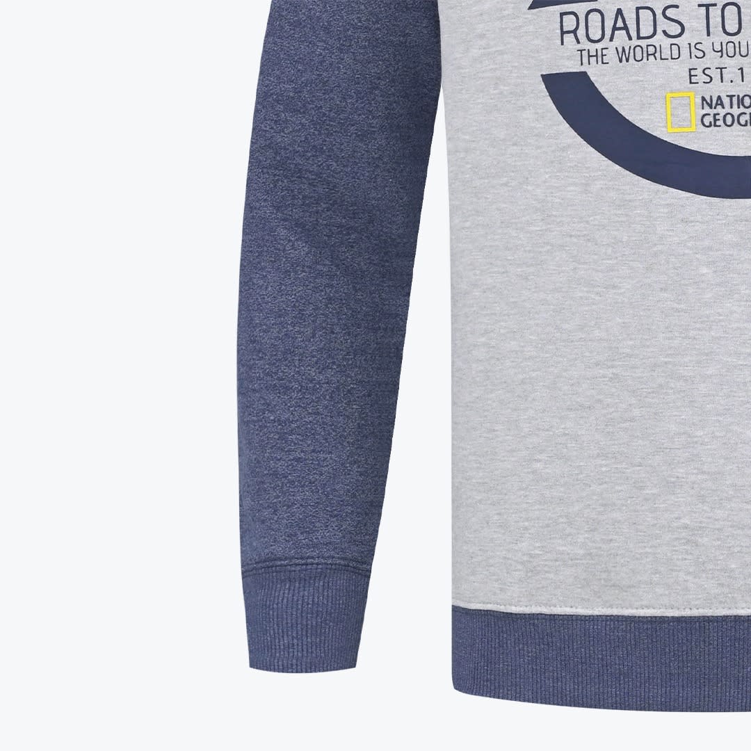 Close-up of a grey and blue National Geographic sweatshirt showing the sleeve cuff, bottom hem, and partial graphic print.