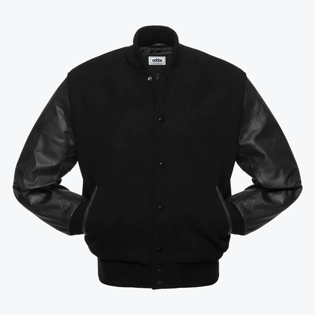 Front view of an all-black varsity jacket with a wool body, textured leather sleeves, and snap button closure against a plain white background.