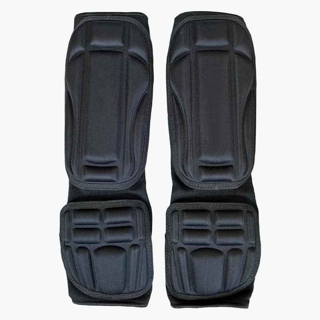 A pair of black padded shin and instep guards for martial arts, displayed vertically side-by-side on a white background.
