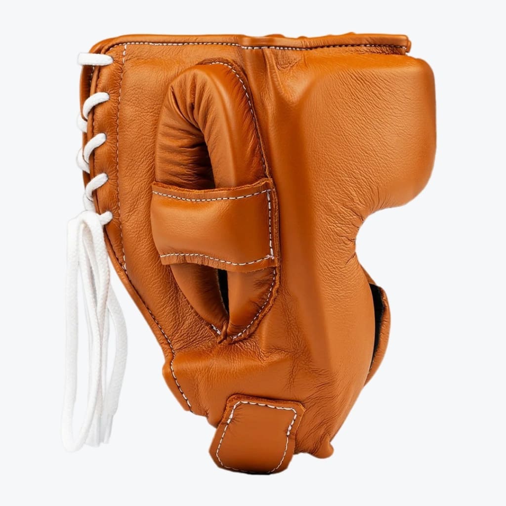 A side view of a premium tan leather boxing headgear with white lace-up closure on a plain white background.