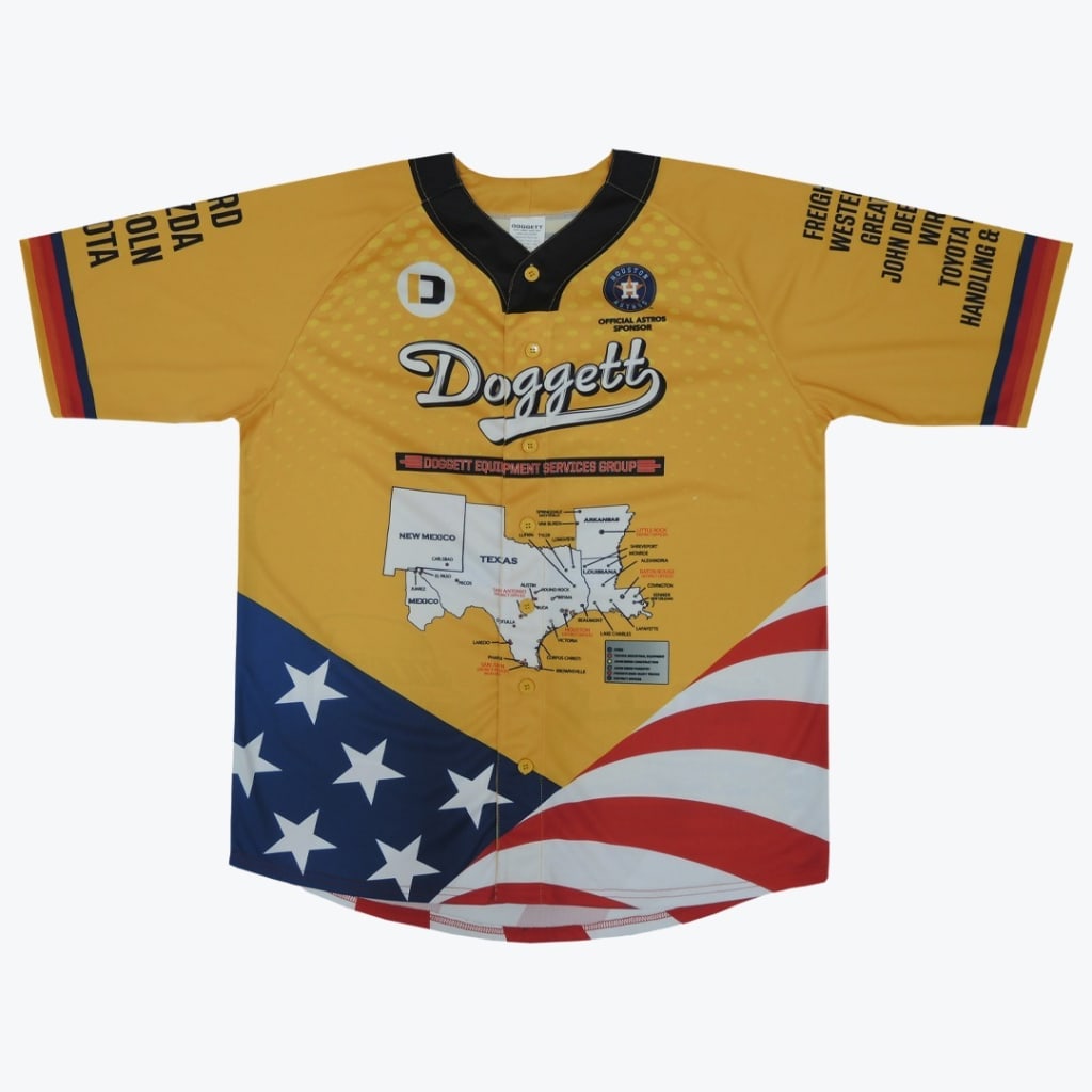 A yellow baseball jersey with a black collar, featuring the Doggett logo, a Houston Astros sponsor badge, a map of the South-Central US, and an American flag design across the bottom hem.