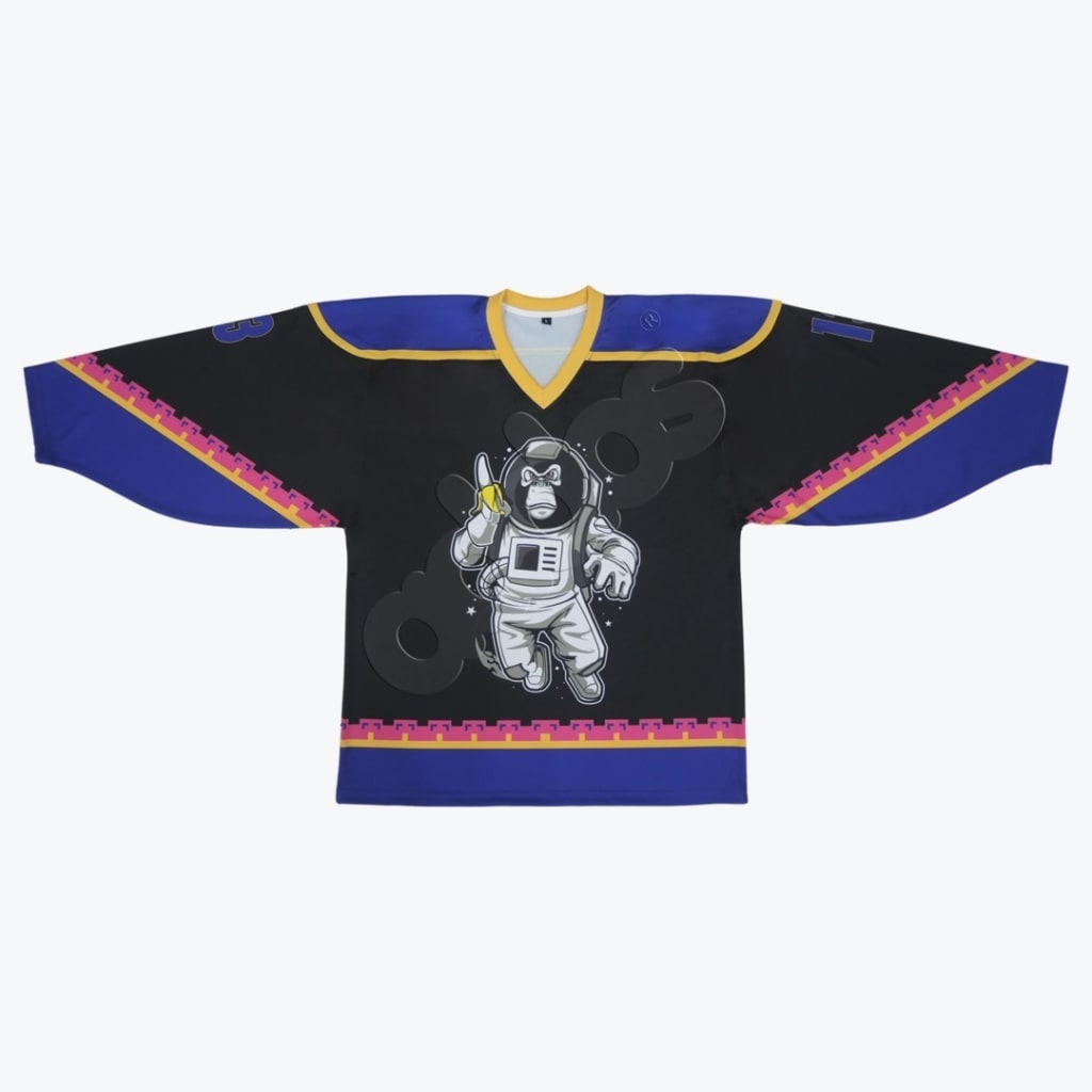 A black and blue hockey jersey laid flat, featuring a cartoon astronaut gorilla holding a banana on the front.