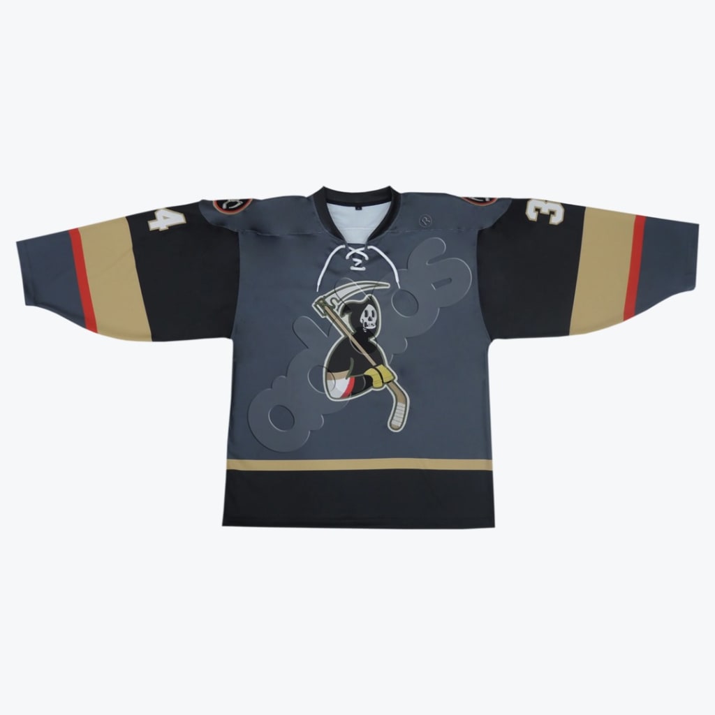 A grey and black hockey jersey with a cartoon Grim Reaper holding a hockey stick scythe on the front, featuring gold and red sleeve stripes.