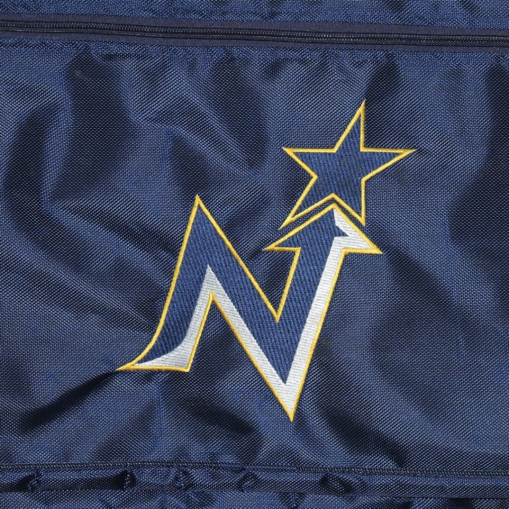 Close-up of a stylized letter N and star logo embroidered in blue, white, and gold on a dark blue textured fabric.