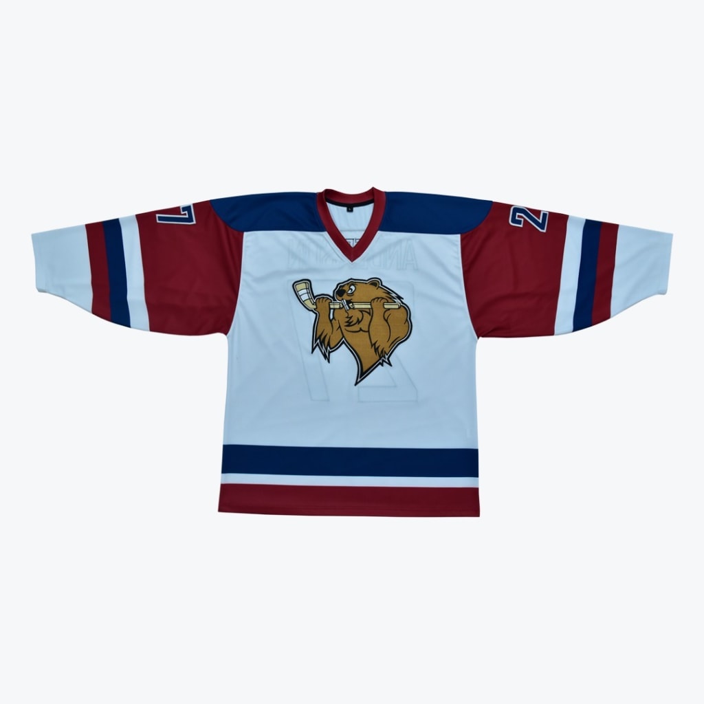 A white hockey jersey with maroon sleeves, navy blue shoulders, and a cartoon beaver logo holding a hockey stick on the front.