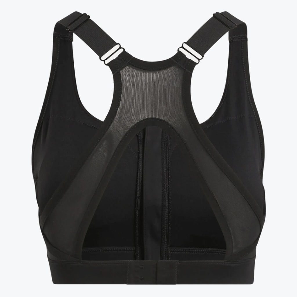 Back view of a black sports bra featuring a mesh racerback panel, adjustable straps, a triangular cutout, and a hook-and-eye closure on a white background.
