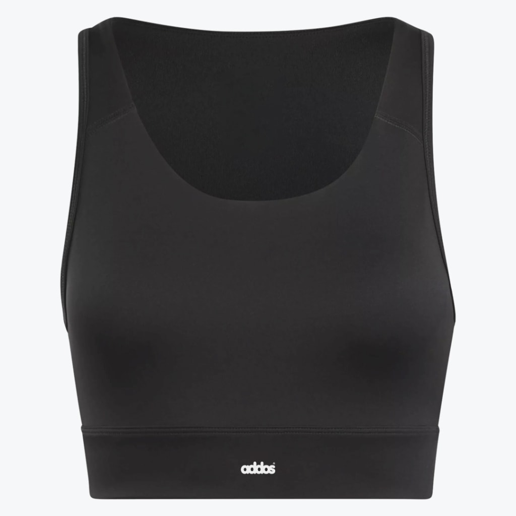 A black sports bra with a scoop neck and a wide underband featuring a small white logo, shown against a plain white background.