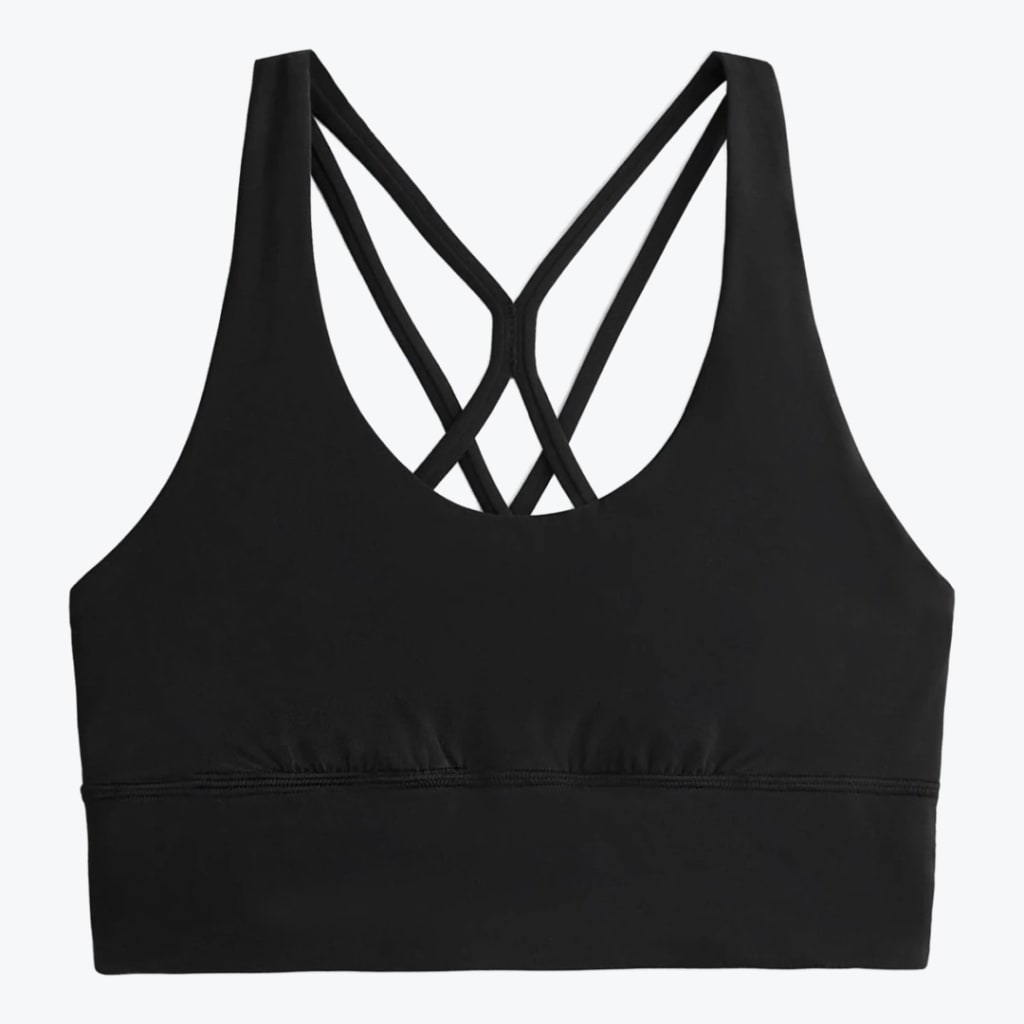 A black sports bra with a scoop neck and a multi-strap criss-cross back design, displayed flat on a white background.