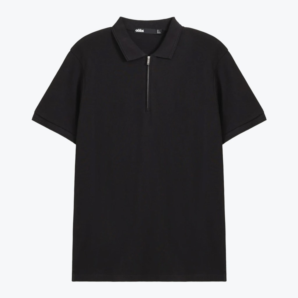 A flat lay of a black short-sleeved polo shirt with a silver half-zip collar on a white background.