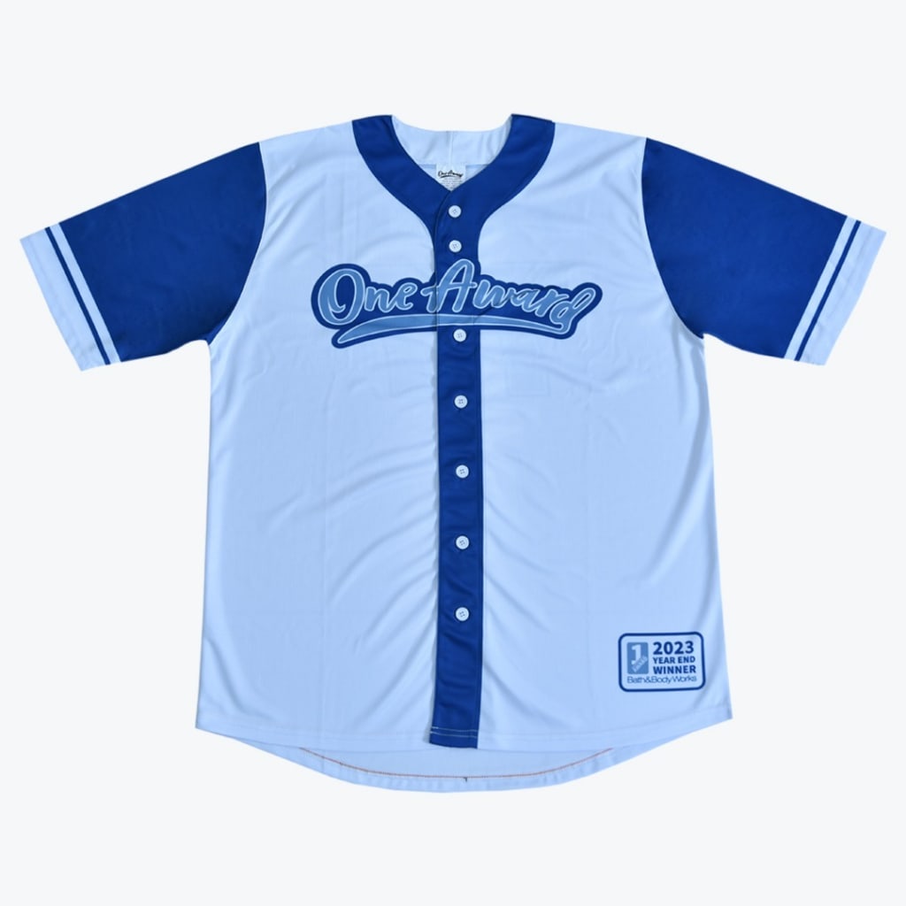 A light blue and royal blue baseball jersey with One Award on the chest and a 2023 Year End Winner Bath Body Works patch on the bottom right.