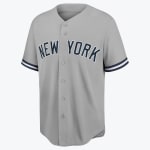 A grey New York Yankees road baseball jersey with NEW YORK in navy blue and white lettering across the chest, featuring a button-down front and striped sleeve cuffs.
