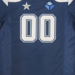A close-up of a navy blue sports jersey featuring the number 00 in white, with a silver star logo on the left and a blue cube logo on the right.