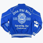 Back view of a royal blue Zeta Phi Beta Sorority varsity jacket with white embroidery showing the sorority name, crest, founding year 1920, and the words 'Sorority, Inc.' and 'Sisterhood'.