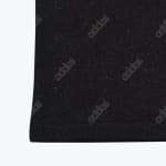 Close-up of black fabric with a white speckled pattern and repeating dark grey Adidas logos.