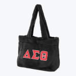 A black plush fuzzy tote bag with the red Greek letters Delta, Sigma, Theta (ΔΣΘ) outlined in white on the front, set against a plain white background.