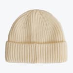A cream-colored ribbed knit beanie hat with a folded cuff, isolated on a plain white background.