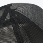 Close-up view of the black mesh back and top button of a trucker hat.