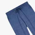Close-up of the elastic waistband and matching drawstring on a pair of blue heathered sweatpants against a white background.