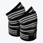 A pair of rolled-up black and white striped athletic knee wraps on a white background.