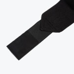 Close-up view of a black elastic wrist wrap strap with a velcro fastening tab on a white background.